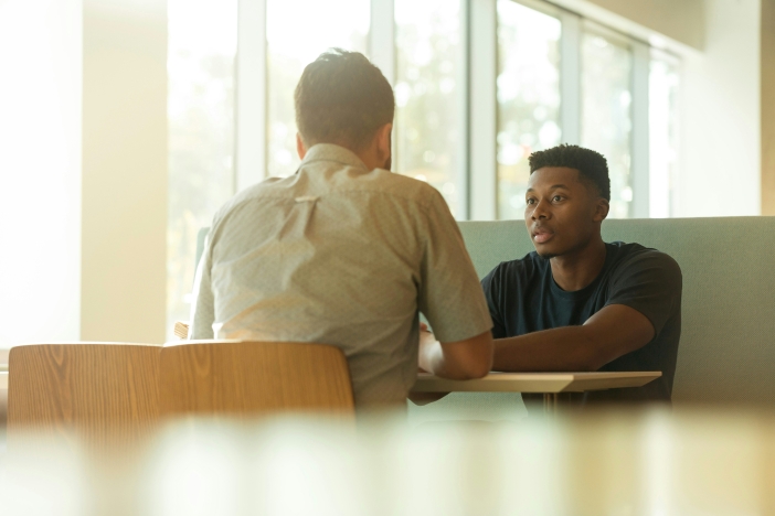 Twee mannen in gesprek met elkaar in een kantooromgeving