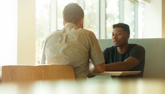 Twee mannen in gesprek met elkaar in een kantooromgeving